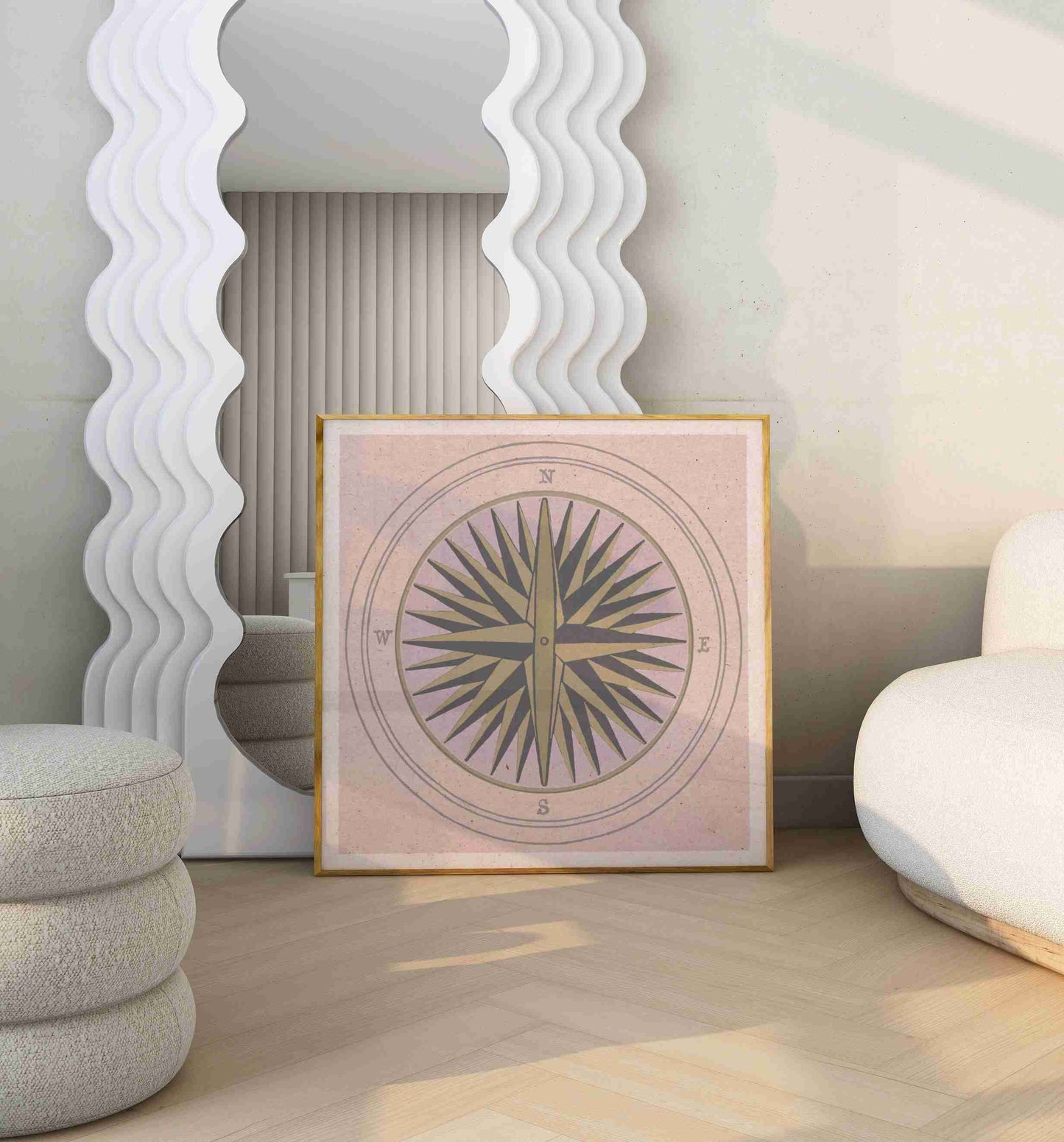 Poster with an illustration of a compass stands in a room with white sofa and big mirror.