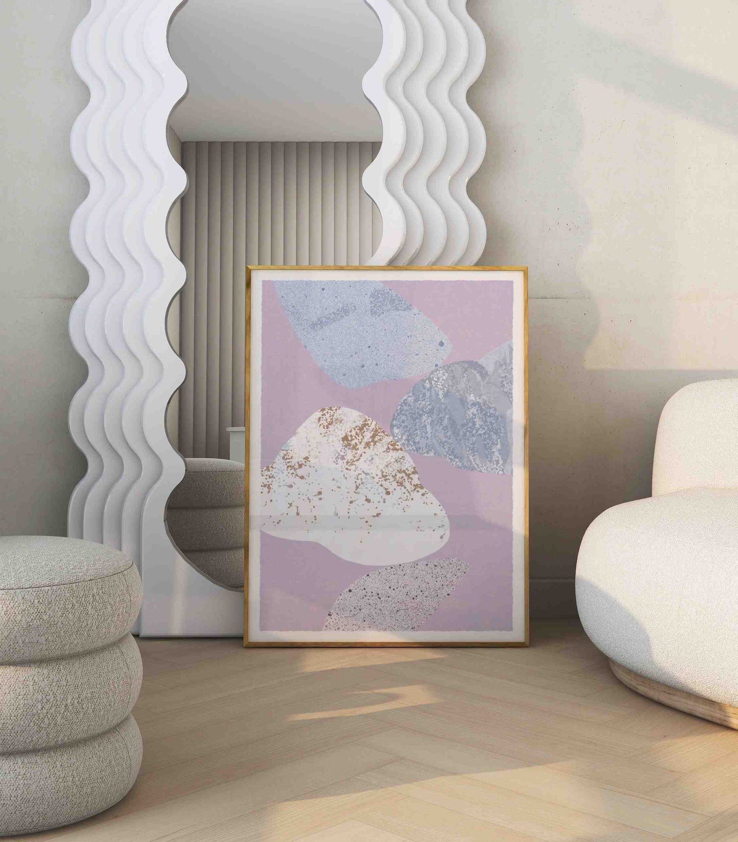 Abstract poster with organic shapes motif stands in a room with white sofa and big mirror.